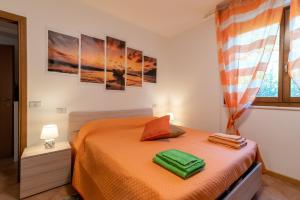 a bedroom with a bed with orange sheets and paintings on the wall at Casaentino in Capolona
