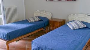 two beds sitting next to each other in a room at Cascina Solaro in Asti +19 photos