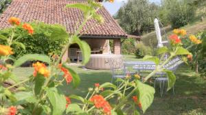 a garden with a table and chairs and flowers at Cascina Solaro in Asti