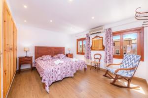 a bedroom with a bed and two chairs in it at Can Binitu in Capdepera +22 photos
