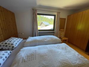 two beds in a bedroom with a window at Fewo 1 am Auweg in Hirschegg