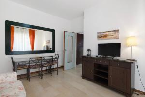 a living room with a flat screen tv on a wall at Marina in Finale Ligure
