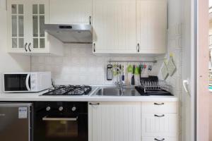 a white kitchen with a sink and a microwave at Marina in Finale Ligure +9 photos