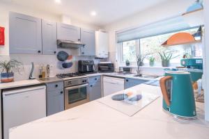 a kitchen with white cabinets and a large window at Faodail in Onich
