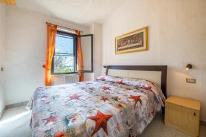a bedroom with a bed with a colorful comforter at Villa Martina in Costa Rei