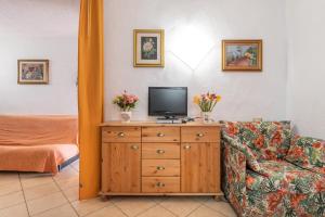 a living room with a couch and a tv on a dresser at Villa Martina in Costa Rei