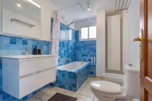a bathroom with a toilet and a tub and a sink at El Pico in La Santa +18 photos