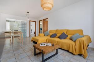 a living room with a yellow couch and a table at El Pico in La Santa