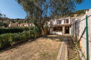 a house with a fence and a tree at Villa Martina in Costa Rei