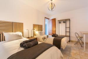 a hotel room with three beds and a window at El Pico in La Santa