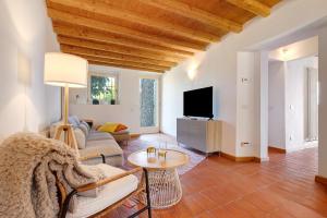 a living room with a couch a table and a tv at Haus mit tollem See -und Bergblick in Gargnano
