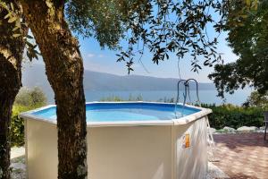 a hot tub sitting next to a tree at Haus mit tollem See -und Bergblick in Gargnano