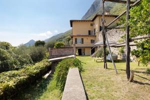 a view of a house with a bench in the yard at Haus mit tollem See -und Bergblick in Gargnano