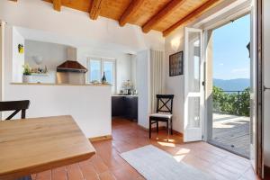 a kitchen and living room with a table and a balcony at Haus mit tollem See -und Bergblick in Gargnano