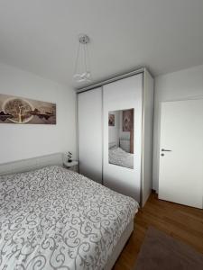 a bedroom with a bed and a large mirror at Bagdala apartman Krusevac in Kruševac