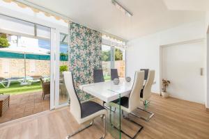 a dining room with a white table and chairs at Nikydan in Cala d´Or