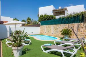 a villa with a swimming pool and lawn chairs at Nikydan in Cala d´Or