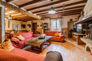 a living room with orange couches and a table at Laguna Herrera in Campo de Cuéllar