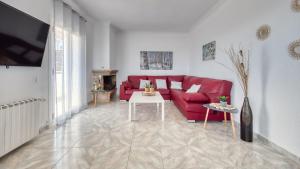 a living room with a red couch and a table at Costacabana - Villa Abigail in Lloret de Mar