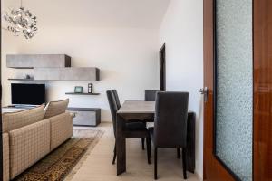 a dining room with a table and chairs and a couch at Wohnung mit grandiosem Ausblick in Tremosine Sul Garda