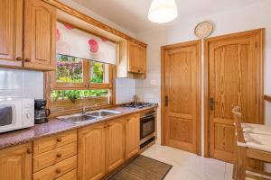 a kitchen with wooden cabinets and a sink and a microwave at Bellavista Port de Soller in Port de Soller +16 photos