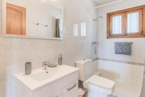 a white bathroom with a toilet and a sink at Bellavista Port de Soller in Port de Soller