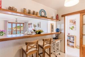 a kitchen with a counter with two chairs and a table at Bellavista Port de Soller in Port de Soller