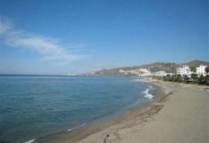 a view of a beach with buildings and the ocean at Casa Galesa in Nerja +4 photos