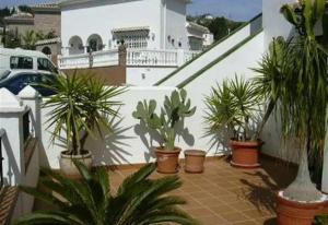 a balcony with potted plants on a white building at Casa Galesa in Nerja