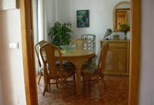 a dining room with a table and chairs and a kitchen at Casa Galesa in Nerja