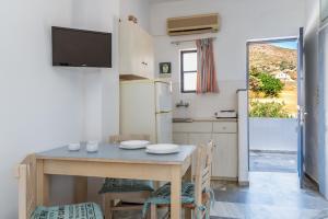 a kitchen and dining room with a table and a tv at Perasma Studio 1b in Kipri