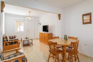 a living room with a table and chairs and a television at Bungalow Desired Track in Santa Pola