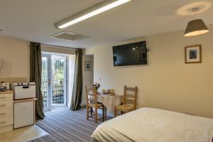 a bedroom with a bed and a kitchen and a table at finest Retreats - Trimstone Manor, Lee Studio Apartment in Woolacombe
