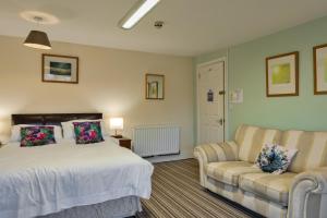 a bedroom with a bed and a couch at finest Retreats - Trimstone Manor, Lee Studio Apartment in Woolacombe +17 photos