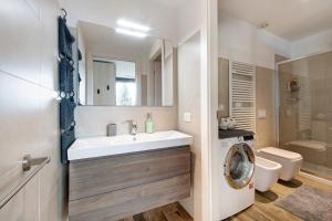 a bathroom with a sink and a washing machine at La Grande Bellezza in Perledo