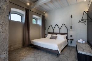 a bedroom with a large white bed and a window at Suite Mezzatorre in San Gimignano +18 photos