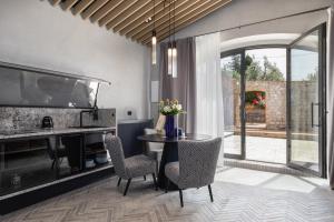 a dining room with a table and chairs and a kitchen at Suite Mezzatorre in San Gimignano