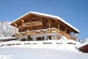 a chalet in winter with snow on the ground at Gästehaus Panorama - Appartement 2 in Reit im Winkl +9 photos