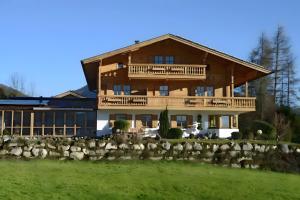 a large wooden house with a fence in front of it at Gästehaus Panorama - Appartement 2 in Reit im Winkl