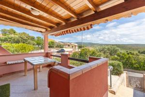 a patio with a table and a wooden pergola at Casa Erbì in Torre Dei Corsari