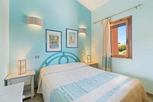 a blue bedroom with a bed and a window at Casa Erbì in Torre Dei Corsari