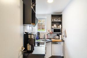 a small kitchen with white cabinets and a sink at Ferienwohnung am West-östlichen Tor in Ecklingerode