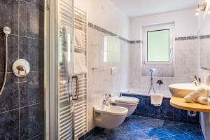 a bathroom with a toilet and a sink and a tub at Salman in Ortisei +21 photos