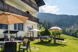 a patio with tables and umbrellas in front of a building at Salman in Ortisei