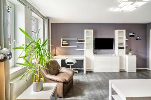 a living room with a couch and a tv at Ferienwohnung am West-östlichen Tor in Ecklingerode