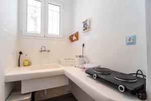 a bathroom with a sink and a suitcase on a counter at Livadia Seaside Studios 1 in Parikia +35 photos