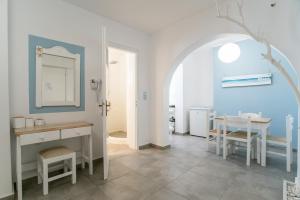 a bathroom with a sink and a table with a mirror at Livadia Seaside Studios 1 in Parikia