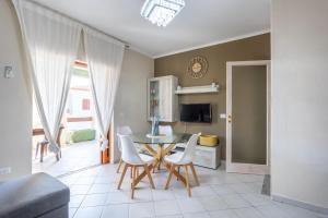 a dining room with a table and white chairs at Casamorle in Isola Rossa