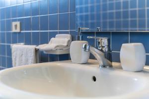 a bathroom with a sink with two soap dispensers on it at Casamorle in Isola Rossa +15 photos