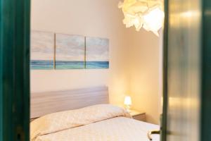 a bedroom with three paintings of the ocean at Casamorle in Isola Rossa